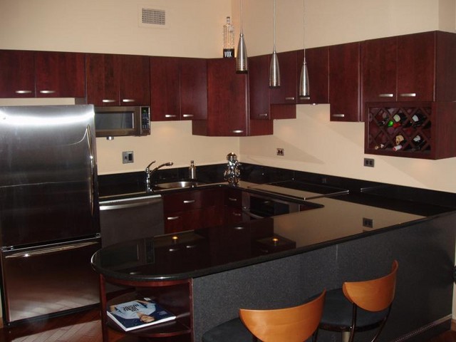 Cherry kitchen cabinets with black appliances